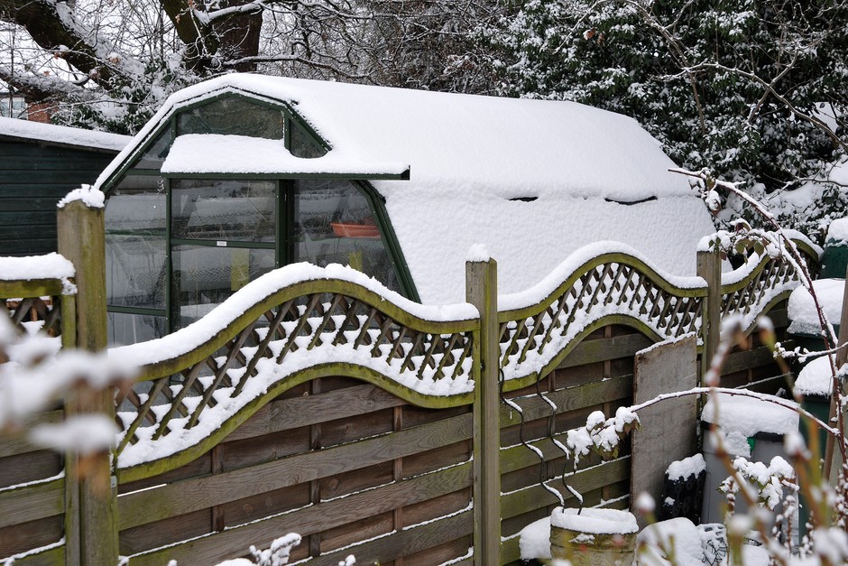 A greenhouse blanketed in snow Keeping the heat in your greenhouse in winter